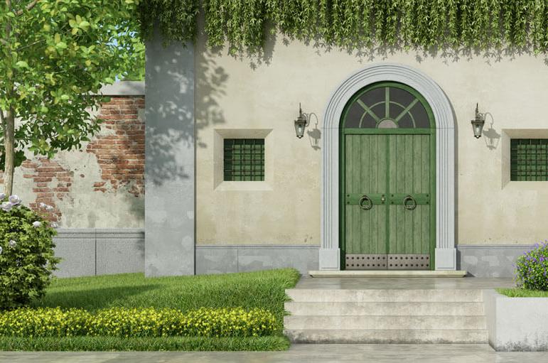 A vintage house set in the forest with a green door.